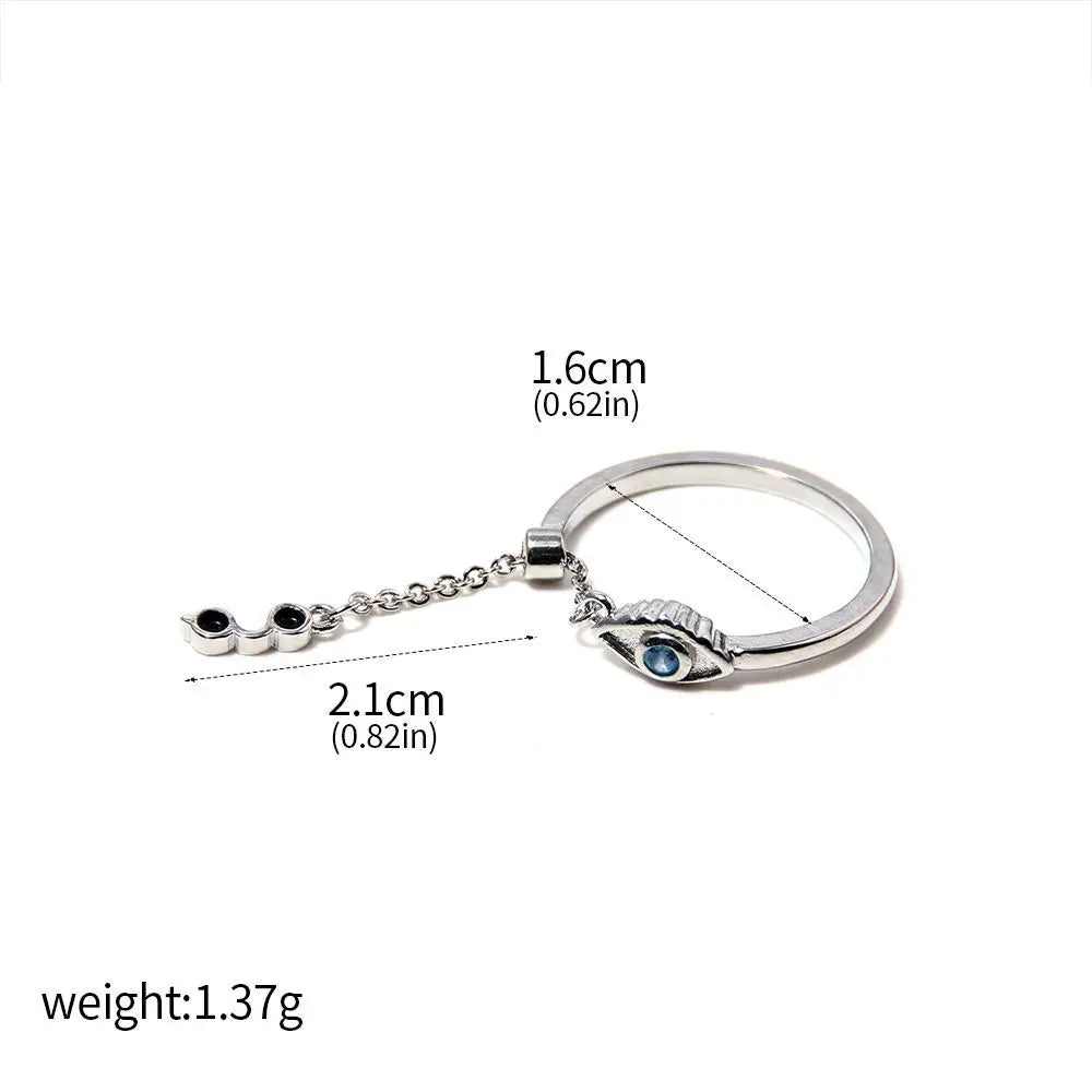 Bague argentée avec pendentif en forme d’œil bleu et chaînette.