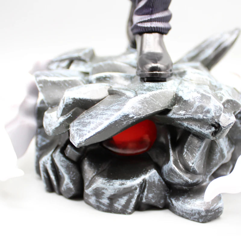 Gros plan du socle rocheux de la figurine Gojo Satoru avec œil rouge.