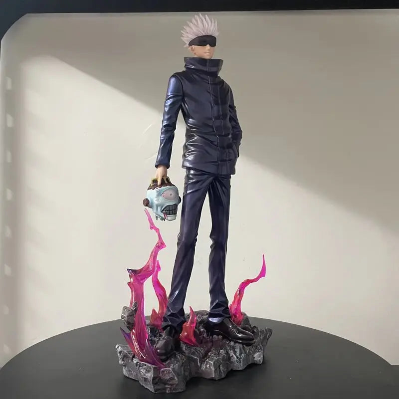 Figurine en tenue noire, cheveux blancs, tenant une tête grise, flammes roses sur socle.