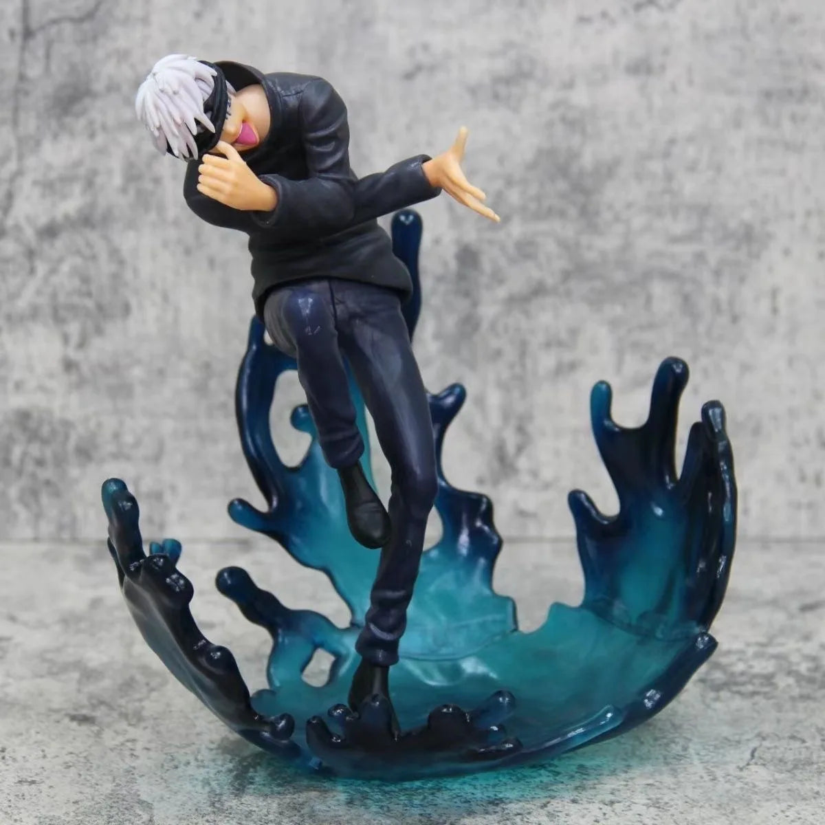 Figurine Jujutsu en tenue noire, cheveux blancs, mains tendues, posée sur base d’énergie bleue