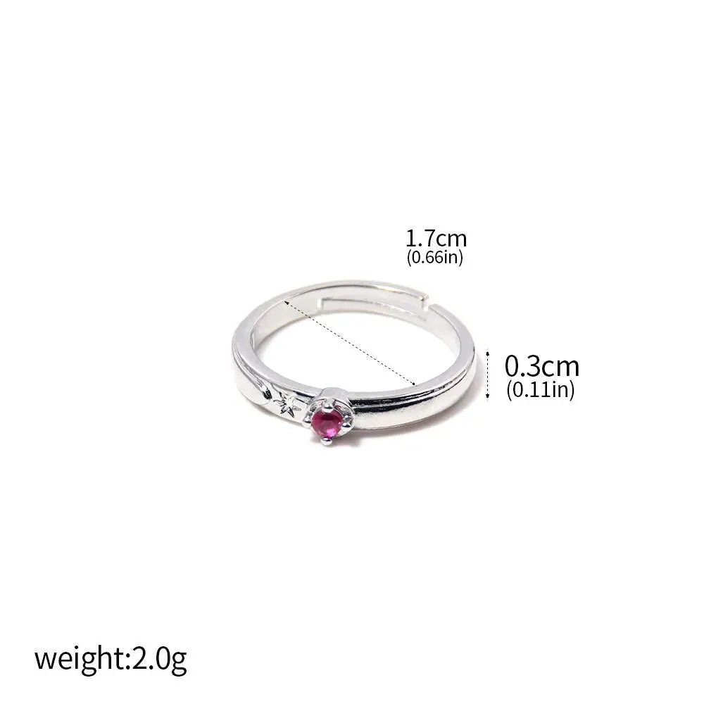 Bague argentée avec pierre rose centrale et motifs gravés discrets sur le bord.