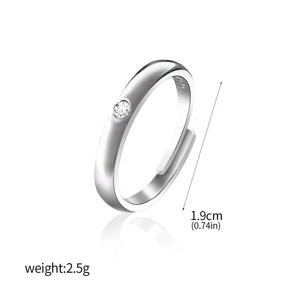 Bague argentée à bord bombé avec une petite pierre claire en serti.