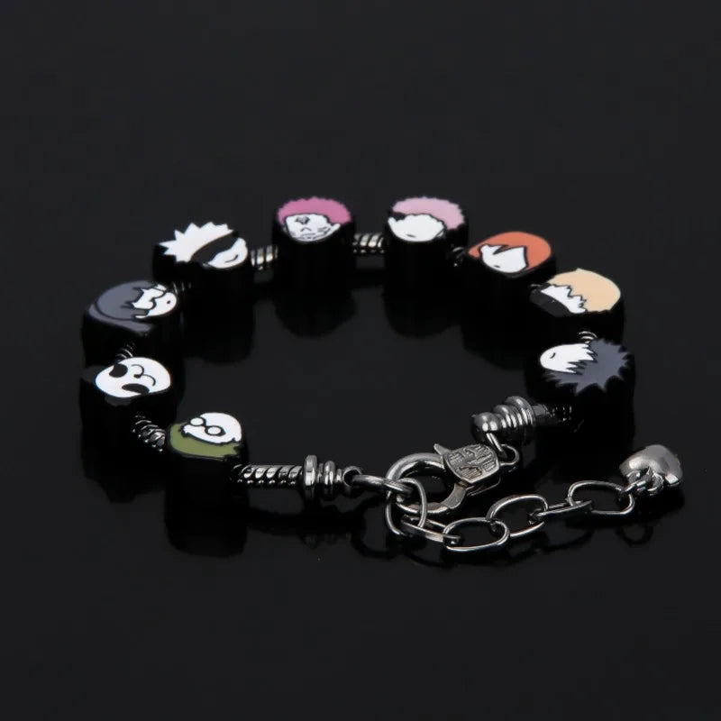 Bracelet avec breloques têtes et motifs colorés, fermoir en métal et chaîne.