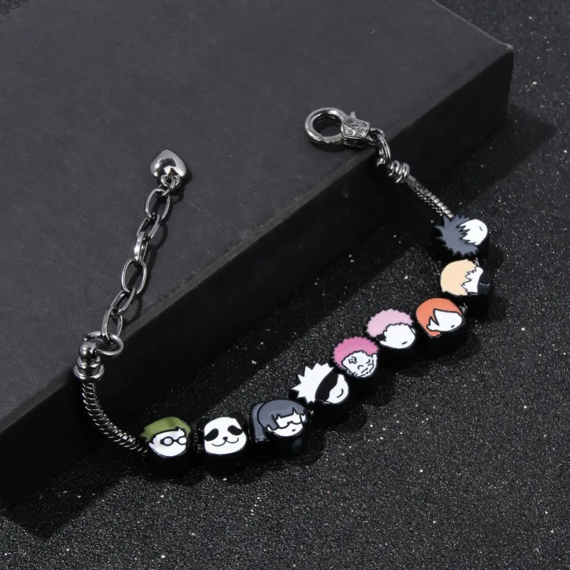 Bracelet à breloques de personnages, maillons argentés, fermoir et perles en émail.