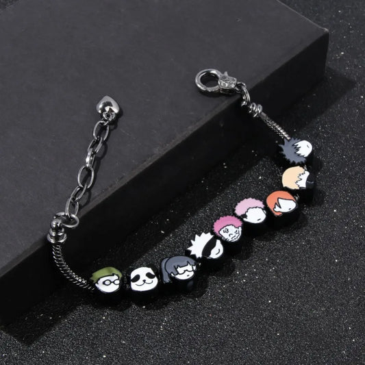 Bracelet à breloques de personnages, maillons argentés, fermoir et perles en émail.