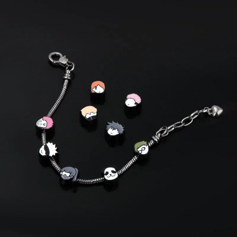 Bracelet à breloques en forme de têtes, chaînes argentées et attache à anneau.