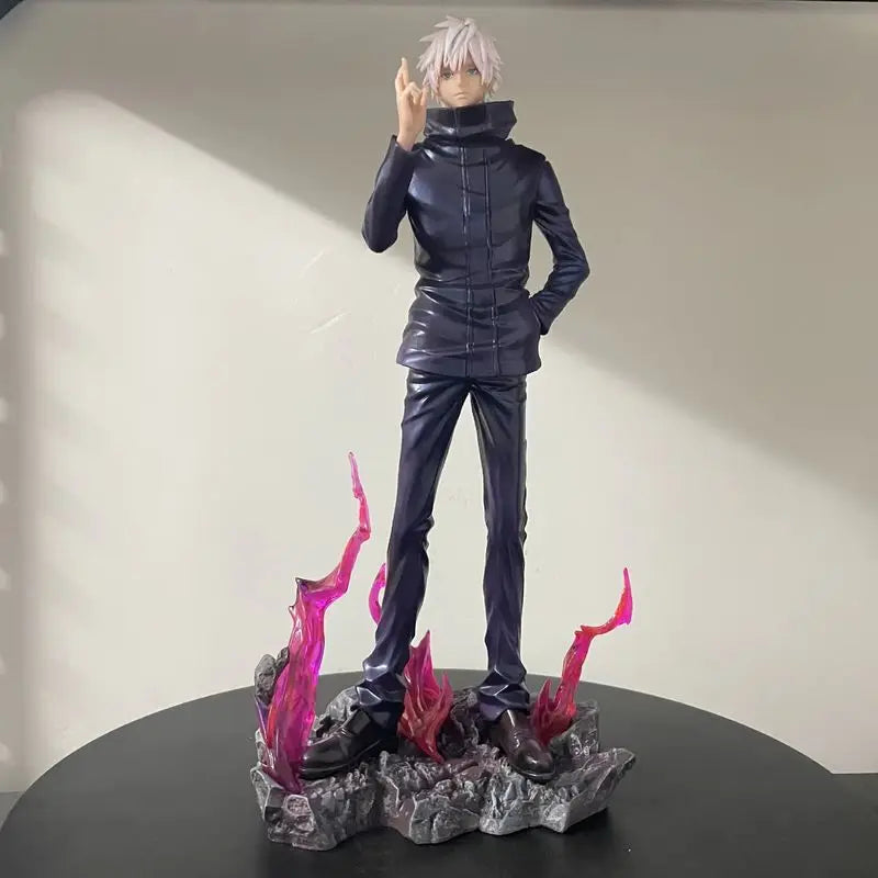 Figurine en tenue noire, cheveux blancs, geste de la main, flammes roses sur socle.