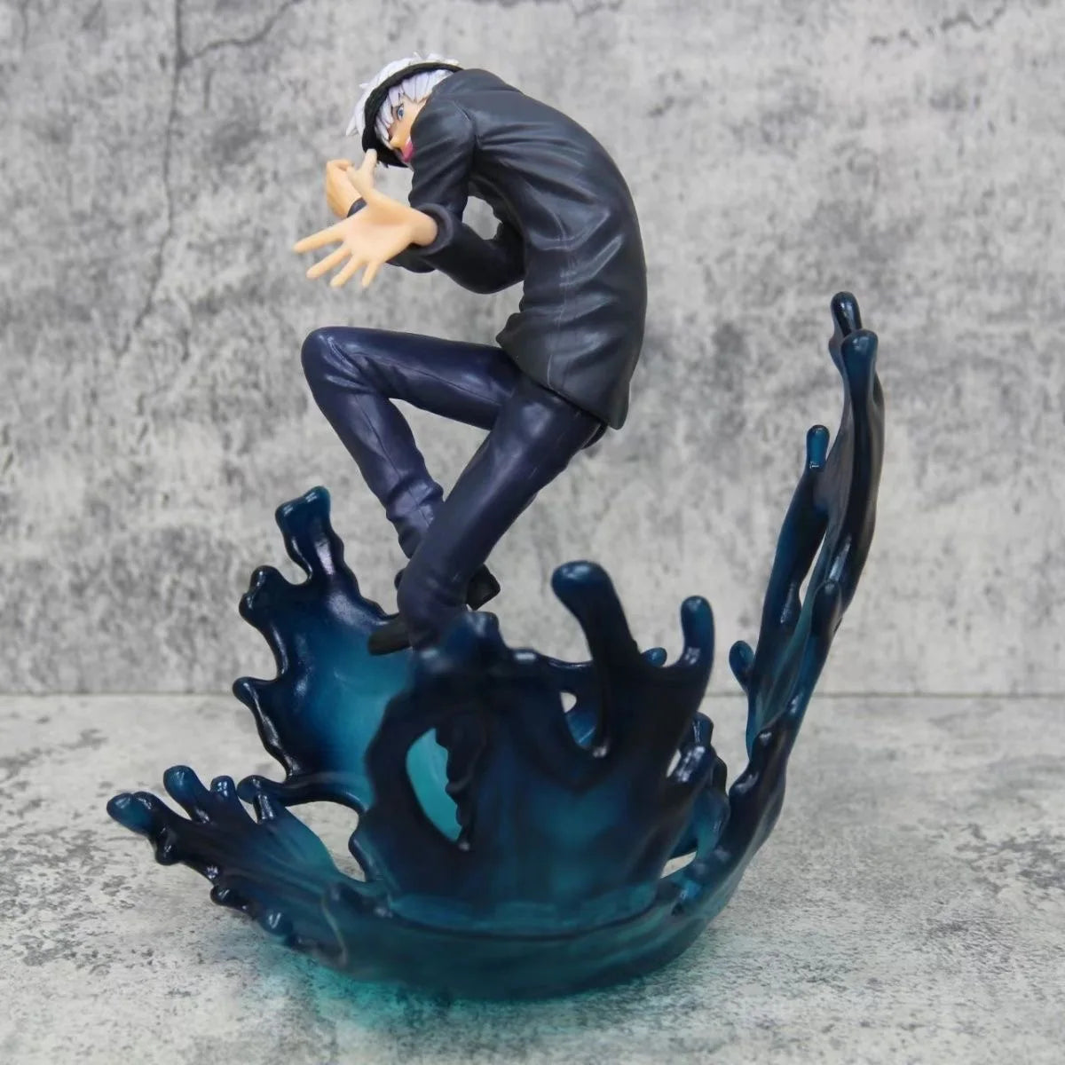 Figurine Jujutsu de profil, cheveux blancs, tenue noire, base d’énergie bleu sombre
