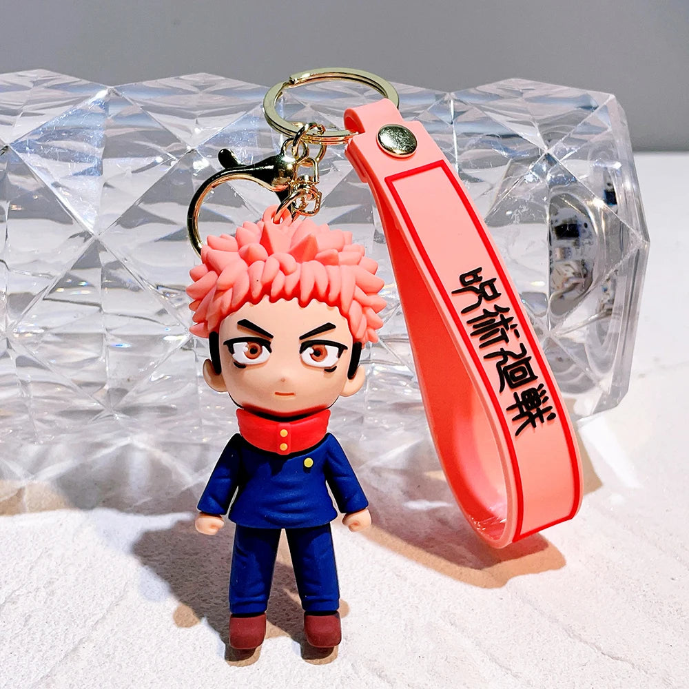 Porte-clé figurine cheveux roses : tenue bleue, lanière rouge, anneau doré et texte noir.